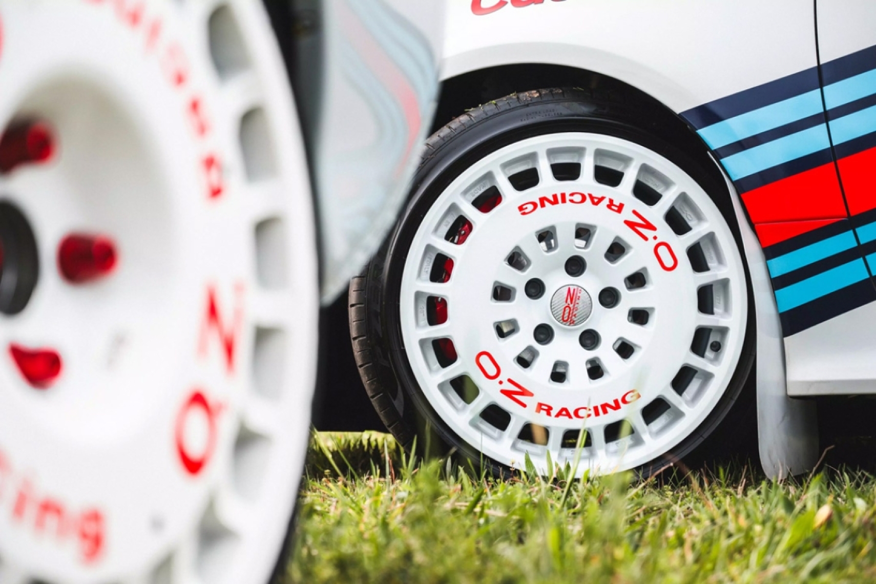 OZ Racing RR40 white alloy wheel shown on a rally-inspired vehicle with red OZ Racing lettering.